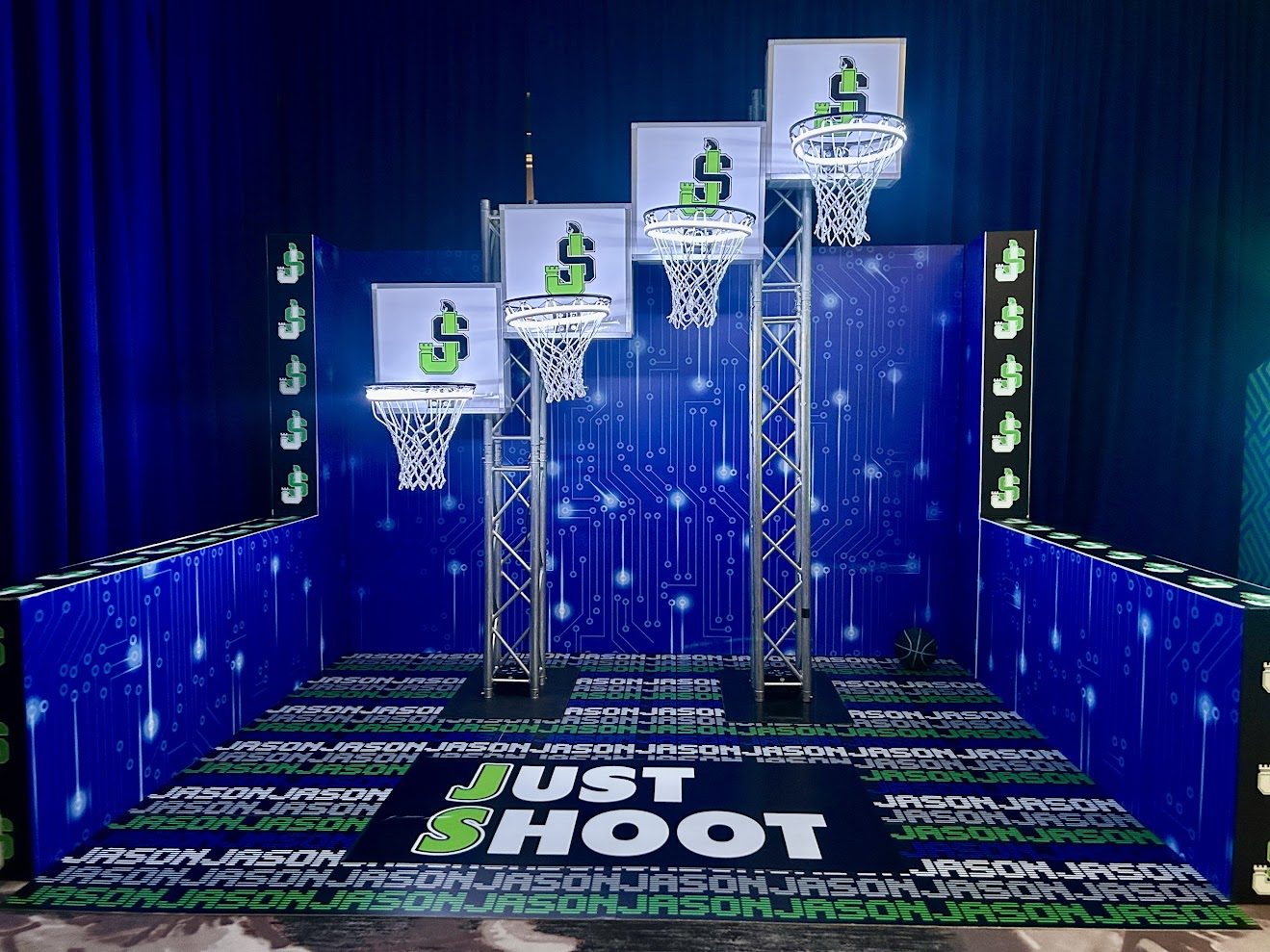 Four-height basketball hoop wall with JS backboards and a Just Shoot floor graphic