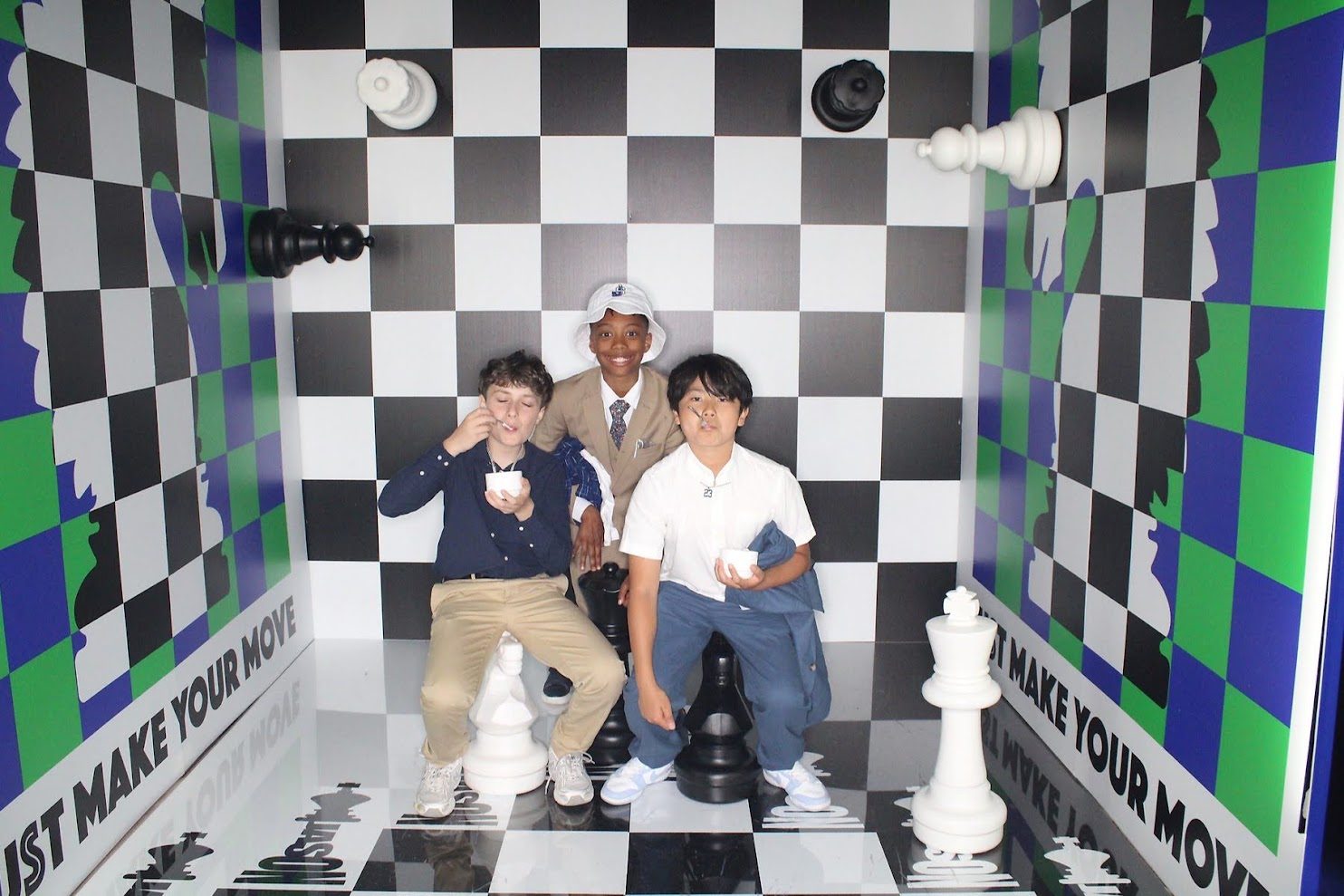 Walk-in chess-board photo booth with giant chess pieces and Just Make Your Move printed on the side walls