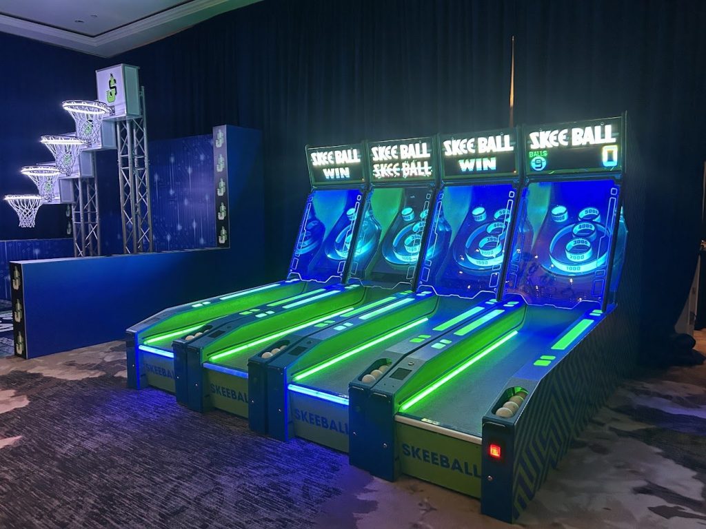 Four LED skee-ball lanes glowing blue and green at a bar mitzvah at The Ritz-Carlton