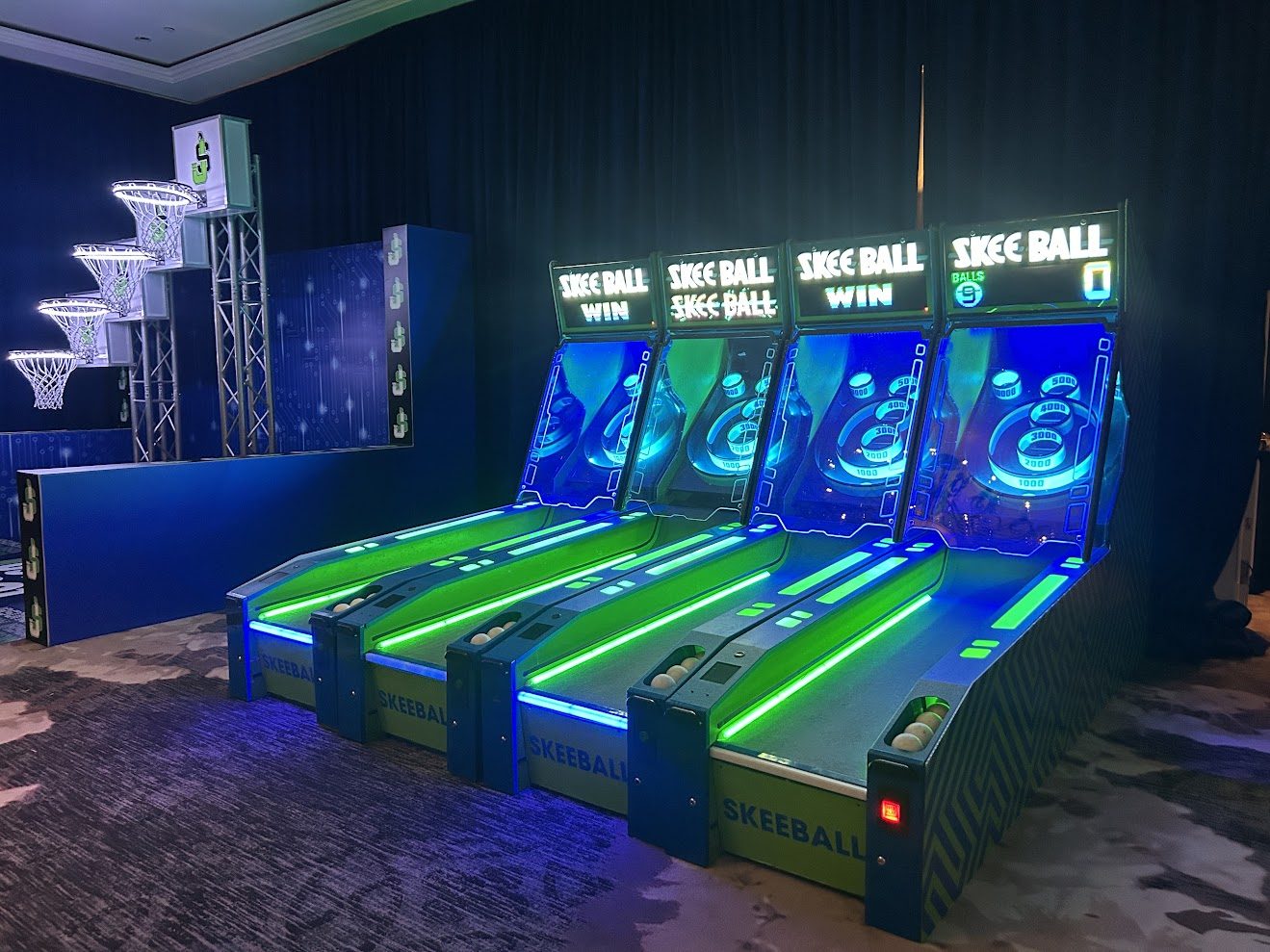 Four lit skee-ball lanes glowing blue and green
