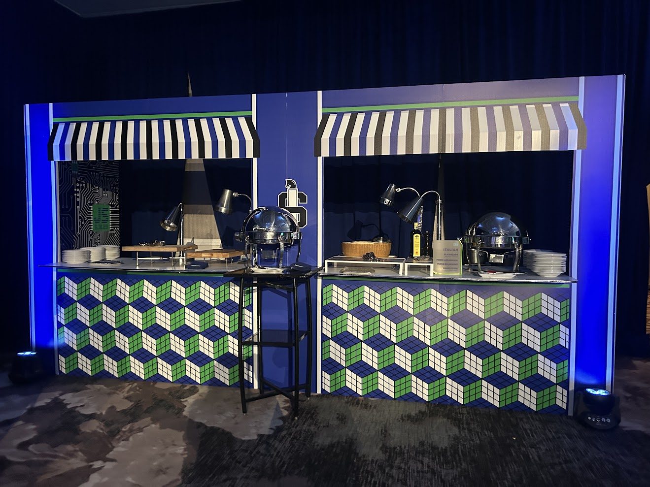 Two food stations with striped awnings and a blue, green and white Rubik's Cube wrap